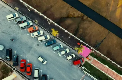 Overhead view of a small paid parking lot with full occupancy.