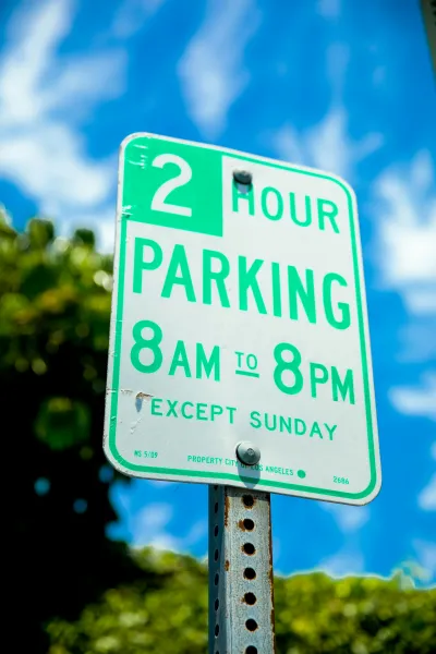 Parking lot signage showing payment instructions and enforcement rules.